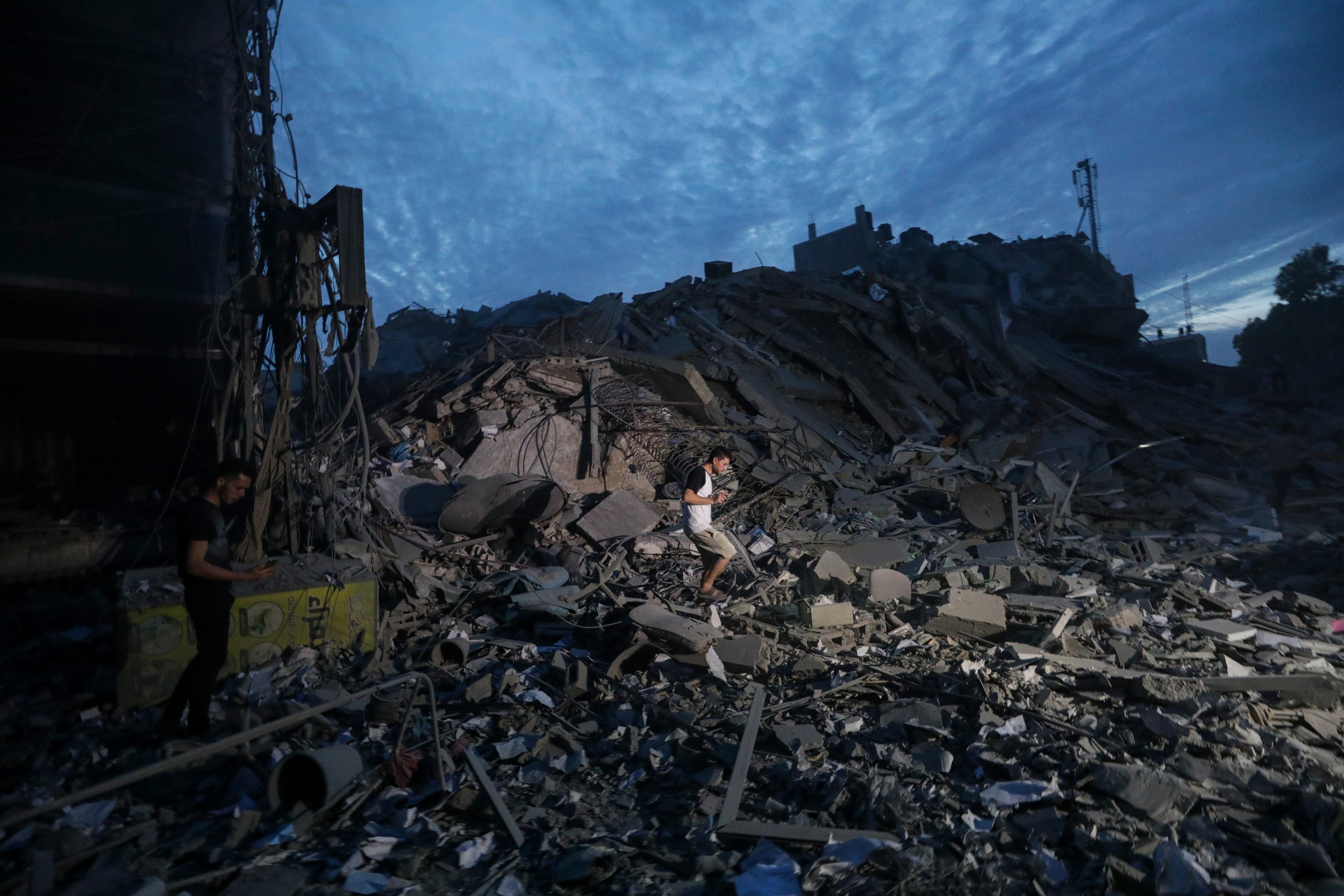 Un palestino camina sobre los escombros de la Torre Palestina tras ser destruida por aviones de combate israelíes el 7 de octubre, día en el que el grupo islamista Hamás lanzó por sorpresa desde Gaza, y en un hecho sin precedentes, un ataque combinado contra el corazón de Tel Aviv con el lanzamiento de 5.000 cohetes e infiltraciones en territorio israelí por tierra, mar y aire con parapentes. EFE/ Mohammed Saber