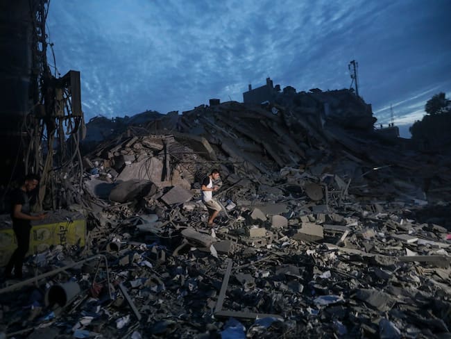 Un palestino camina sobre los escombros de la Torre Palestina tras ser destruida por aviones de combate israelíes el 7 de octubre, día en el que el grupo islamista Hamás lanzó por sorpresa desde Gaza, y en un hecho sin precedentes, un ataque combinado contra el corazón de Tel Aviv con el lanzamiento de 5.000 cohetes e infiltraciones en territorio israelí por tierra, mar y aire con parapentes. EFE/ Mohammed Saber