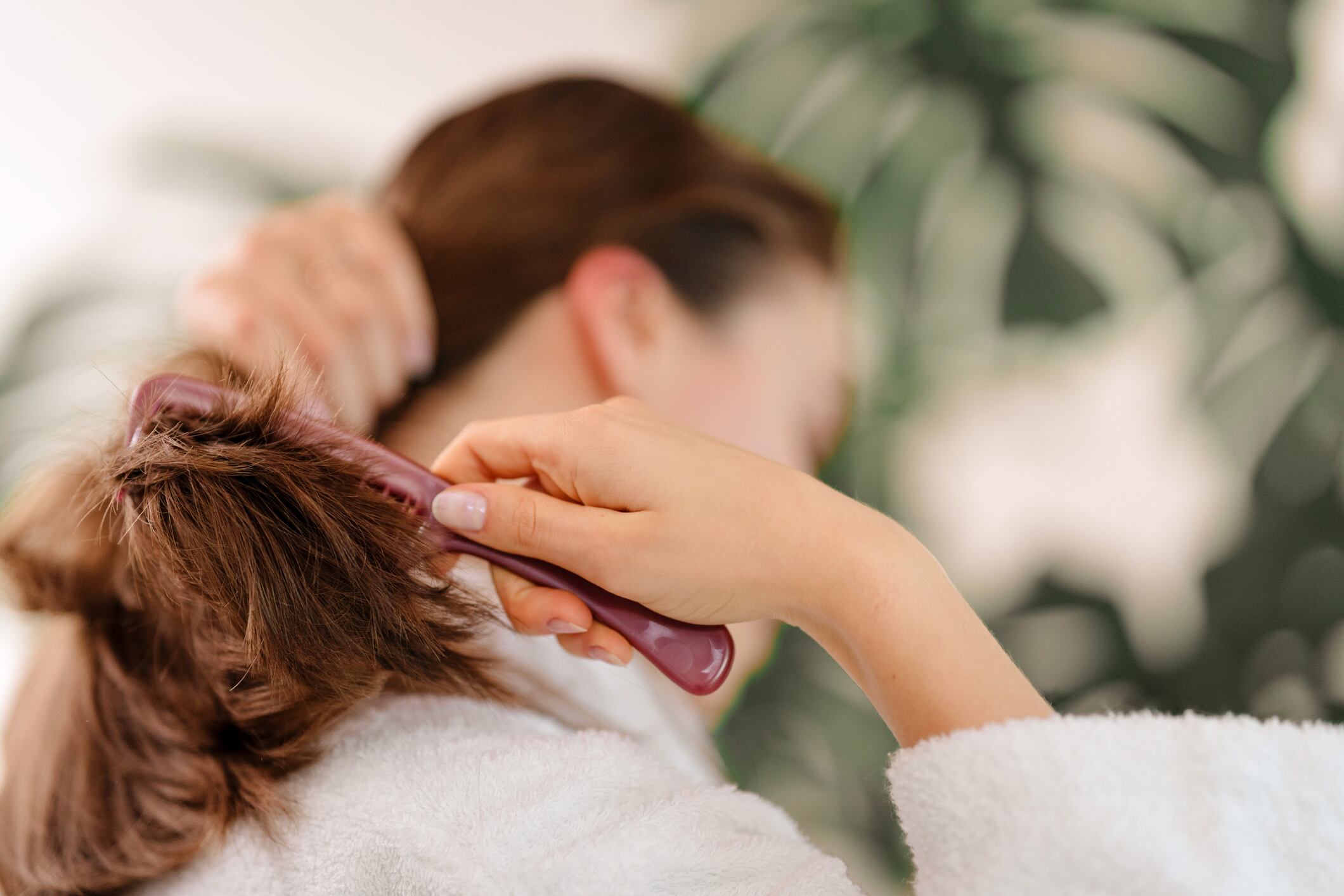 Mujer pasando un cepillo por su cabello (Foto vía Getty Images)