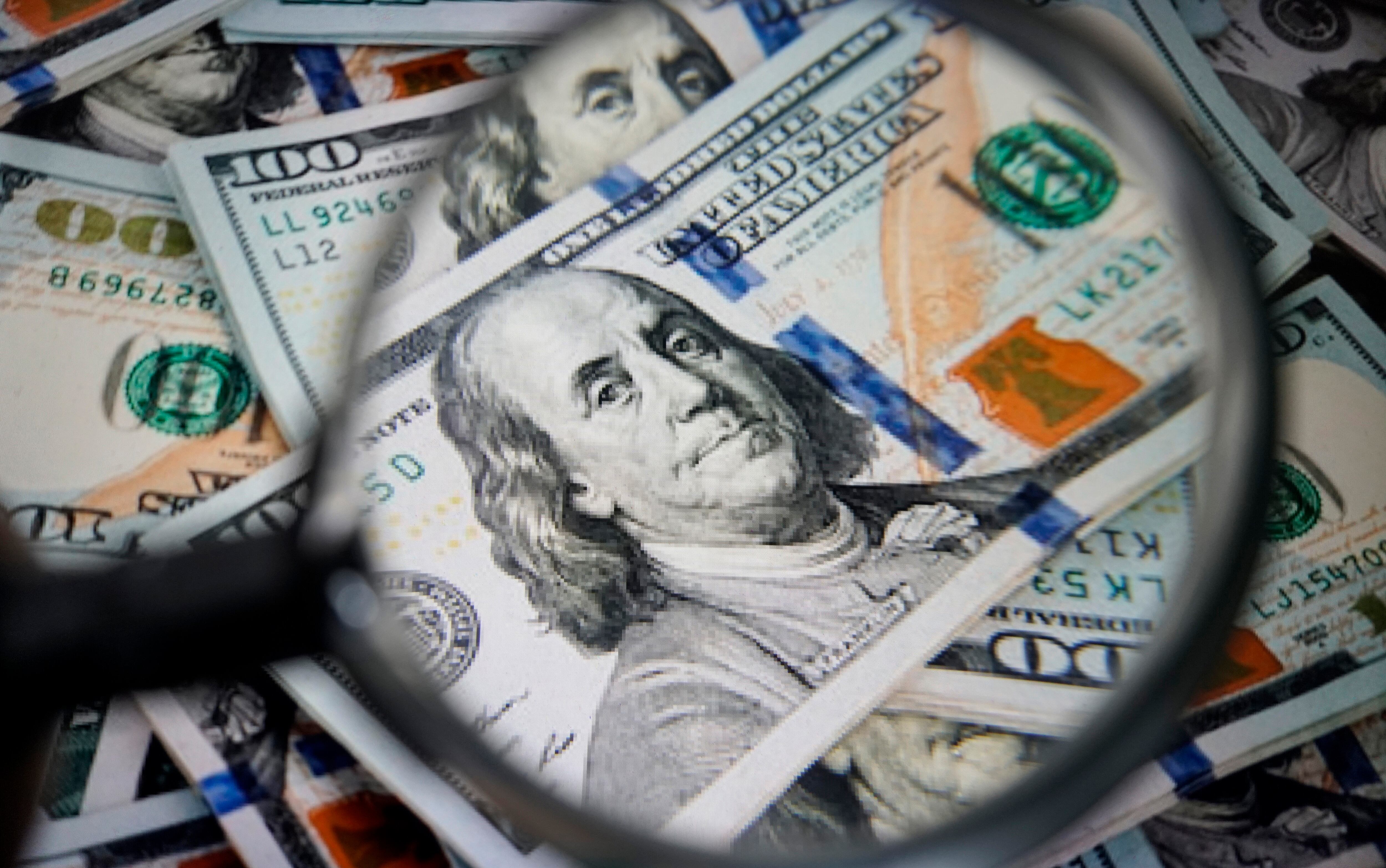 Dólar con una lupa encima (Getty Images)