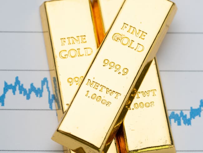 Lingotes de oro sobre una gráfica fluctuante (Foto vía Getty Images)