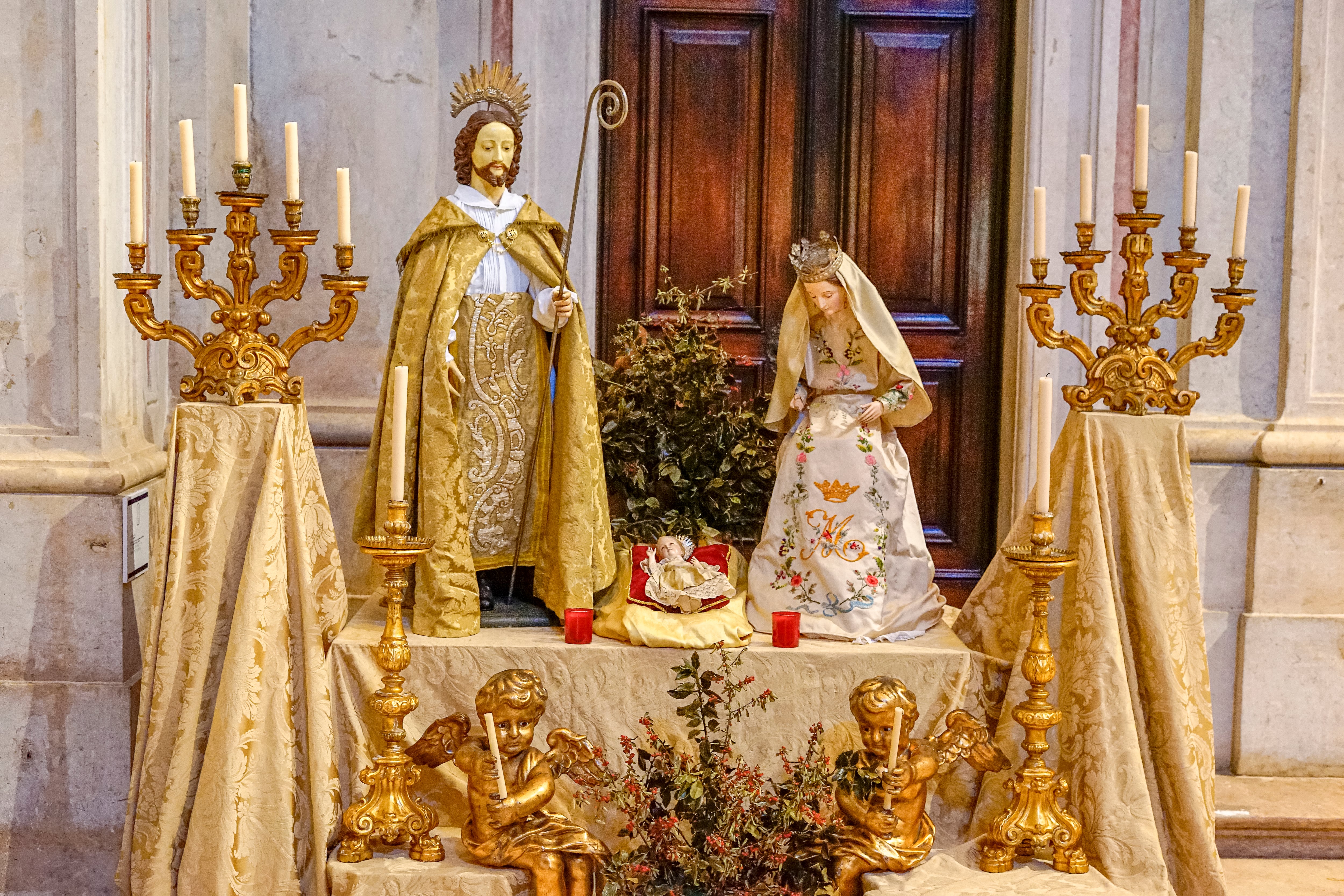 Imagen de referencia de un altar con figuras de la Virgen María, José y Jesús, adornado con manteles y velas (Fotos vía GettyImages)