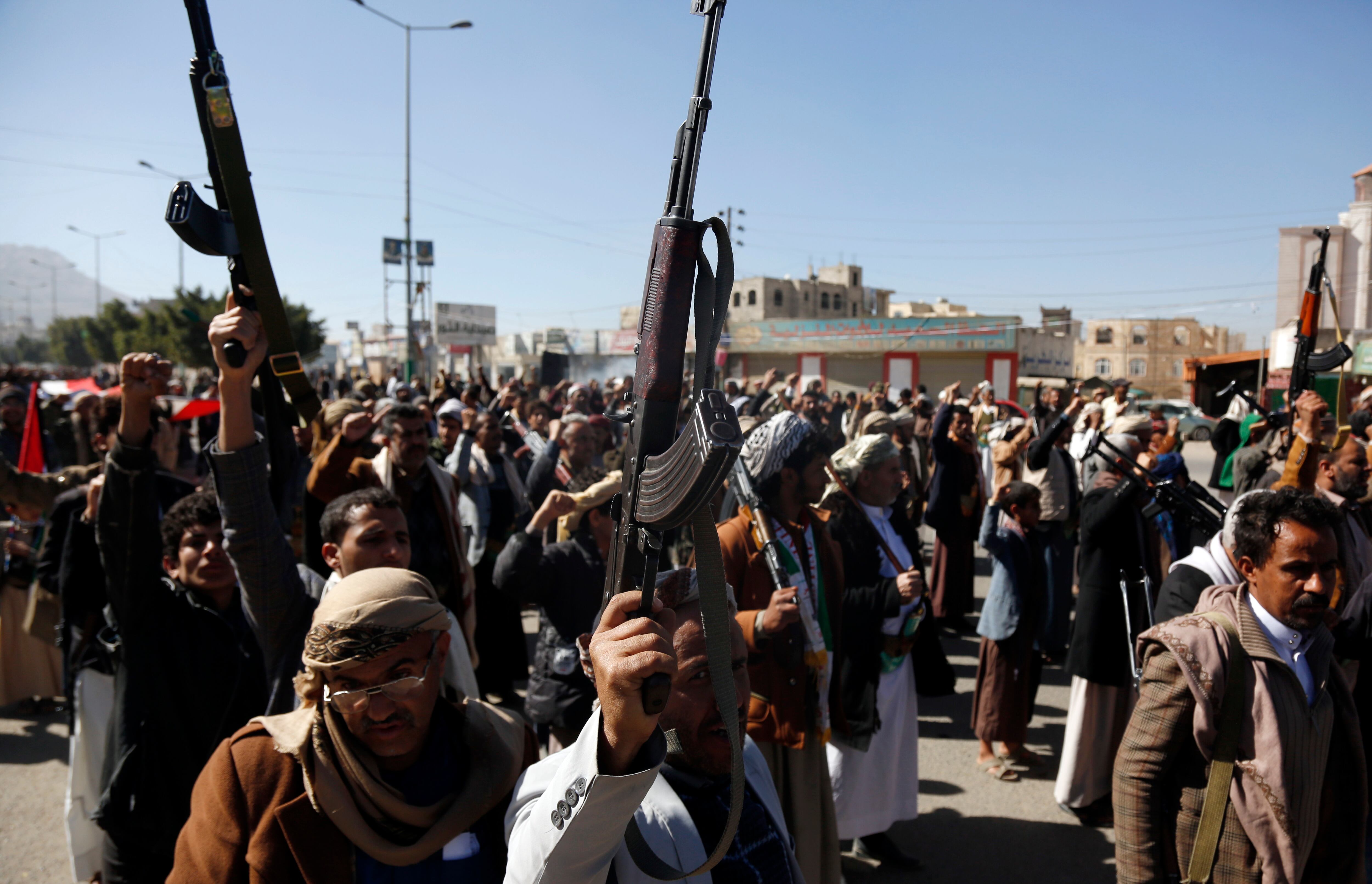 SANA'A, YEMEN - JANUARY 11: Yemeni protestors loyal to the Houthi movement lift their rifles as they participate in a protest held against Israel's ongoing war on Gaza and threats of the U.S. and UK amid U.S. Secretary of State Antony Blinken's warning of a military response to rebel attacks in the Red Sea on January 11, 2024 in Sanaa, Yemen. (Photo by Mohammed Hamoud/Getty Images)