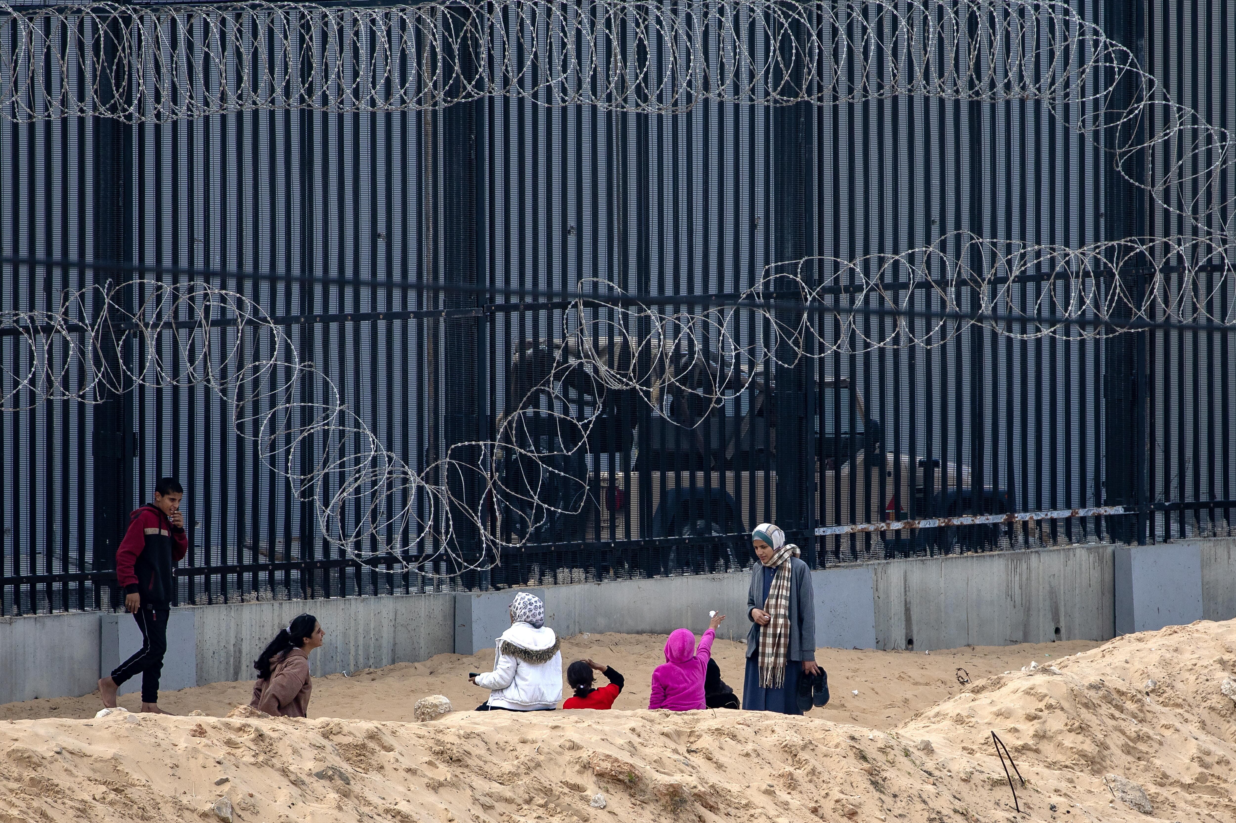 Rafah (-), 11/01/2024.- Displaced Palestinians, who fled their houses due to Israeli strikes, sit near the border with Egypt where they took shelter, in Rafah in the southern Gaza Strip, 11 January 2024. More than 23,400 Palestinians and at least 1,300 Israelis have been killed, according to the Palestinian Health Ministry and the Israel Defense Forces (IDF), since Hamas militants launched an attack against Israel from the Gaza Strip on 07 October, and the Israeli operations in Gaza and the West Bank which followed it. (Egipto) EFE/EPA/HAITHAM IMAD