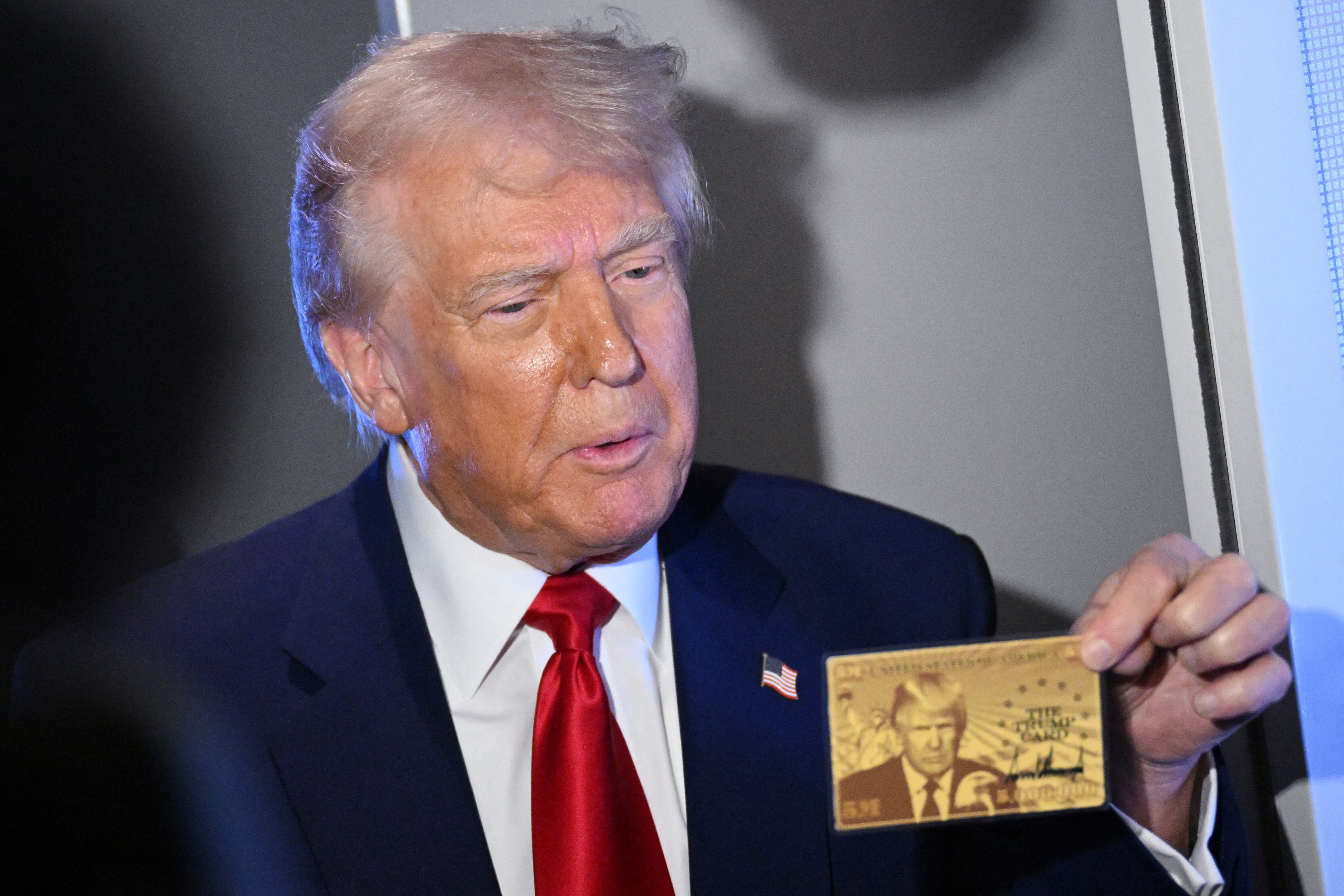 US President Donald Trump holds the $5 million dollar Gold Card as he speaks to reporters while in flight on board Air Force One, en route to Miami, Florida on April 3, 2025. Trump is travelling to the Trump National Doral Golf Club before going to his Mar-a-Lago Resort. (Photo by MANDEL NGAN / AFP) (Photo by MANDEL NGAN/AFP via Getty Images)          