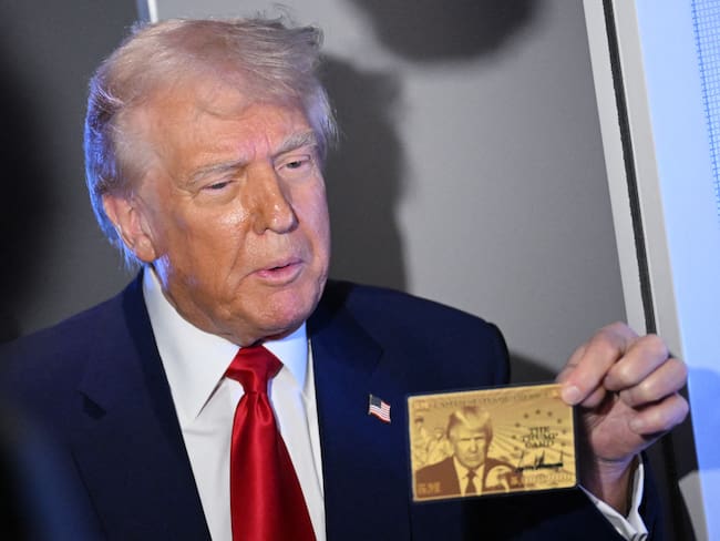 US President Donald Trump holds the $5 million dollar Gold Card as he speaks to reporters while in flight on board Air Force One, en route to Miami, Florida on April 3, 2025. Trump is travelling to the Trump National Doral Golf Club before going to his Mar-a-Lago Resort. (Photo by MANDEL NGAN / AFP) (Photo by MANDEL NGAN/AFP via Getty Images)