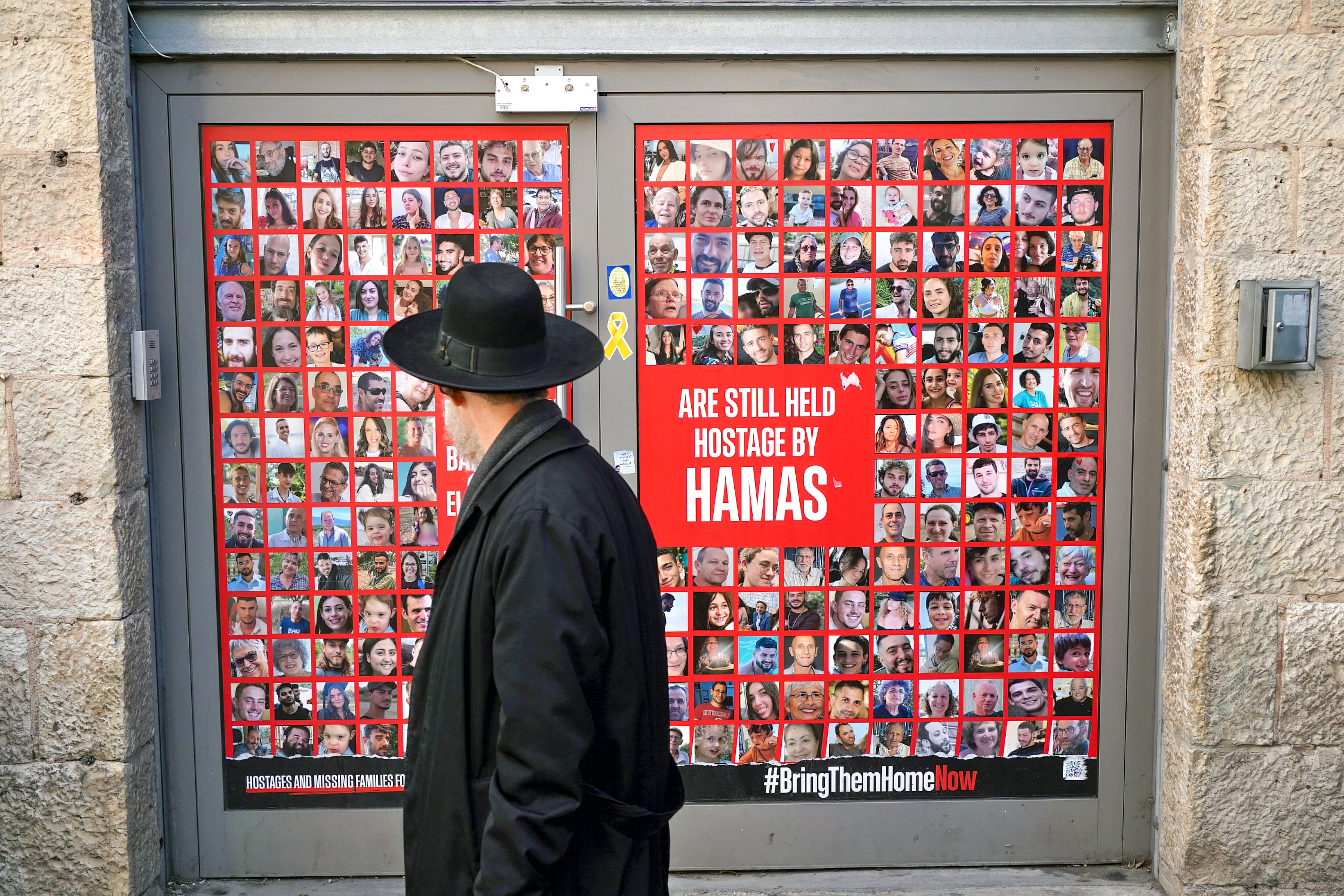 JERUSALÉN, 15/01/2025.- Un hombre camina este miércoles en una calle de Jerusalén delante de fotos de los rehenes israelíes secuestrados por Hamás el 7 de octubre del año pasado. Mientras tanto las autoridades palestinas como israelíes y los medios locales auguran un acuerdo inminente de tregua en la Franja de Gaza, la población de Jerusalén, dividida entre ambas comunidades, coincide en que es el momento de un acuerdo pero mantiene sus reservas respecto al futuro que este deparará. EFE/Alejandro Ernesto