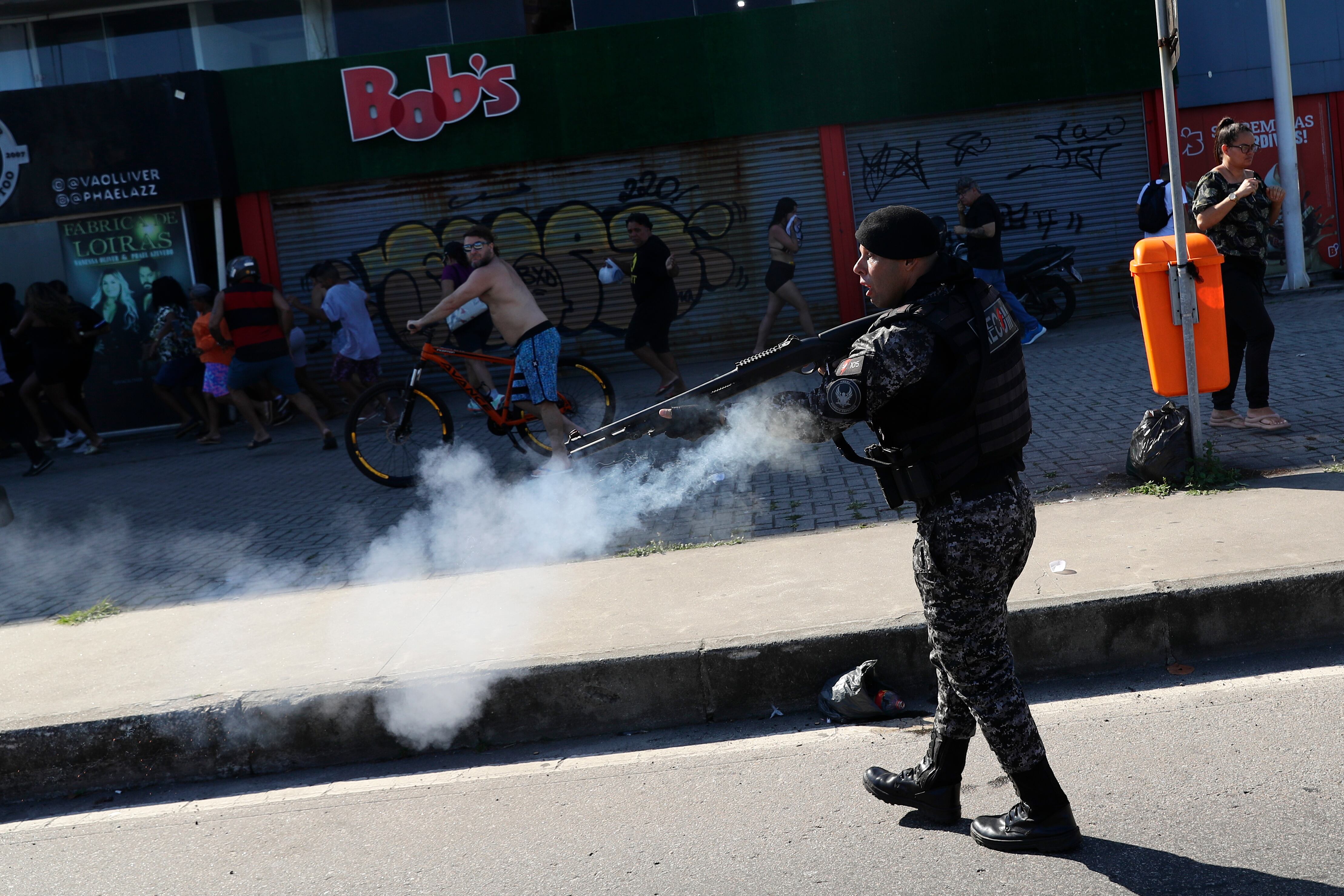 AME247. RÍO DE JANEIRO (BRASIL), 23/10/2024.- Un integrante de la policía dispara durante disturbios con los fanaticos del equipo Peñarol de Uruguay, en la playa de Pontal, este miércoles, en Río de Janeiro (Brasil). Decenas de fanáticos de Peñarol cometieron una serie de actos vandálicos en una playa de Río de Janeiro a horas del partido de ida de las semifinales de la Copa Libertadores con Botafogo, informaron fuentes oficiales. EFE/ André Coelho