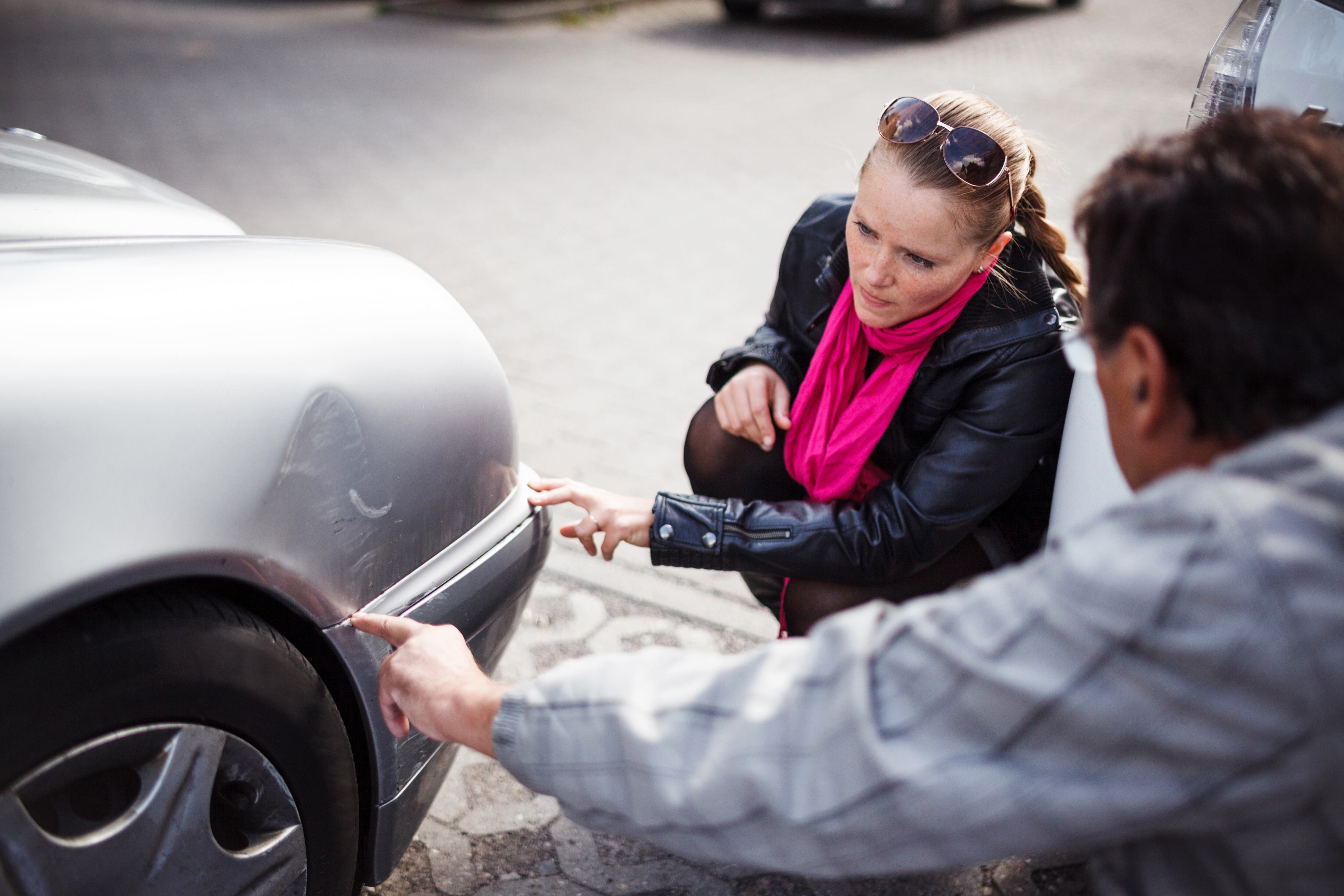 Personas observando los daños de un vehículo tras tener un accidente de tránsito (Foto vía Getty Images)
