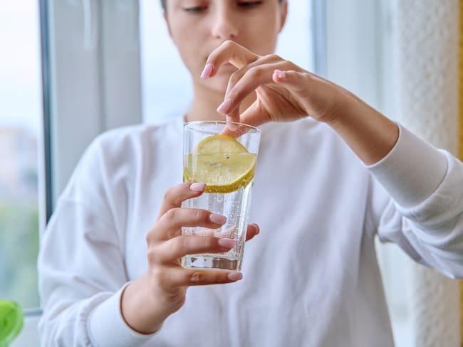 Persona bebiendo agua con limón, foto de referencia: Getty Images