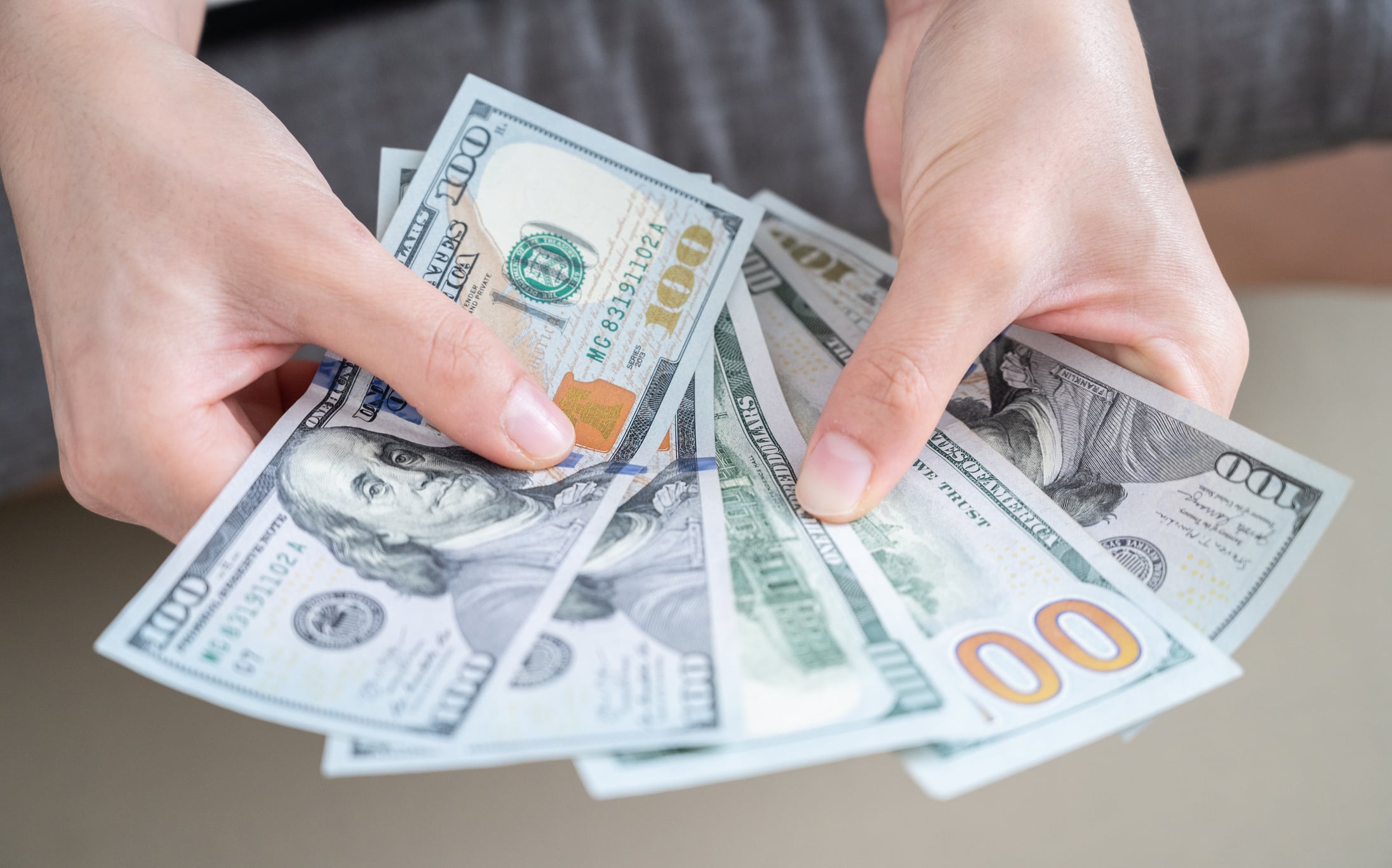 Persona contando dólares, imagen de referencia // GettyImages