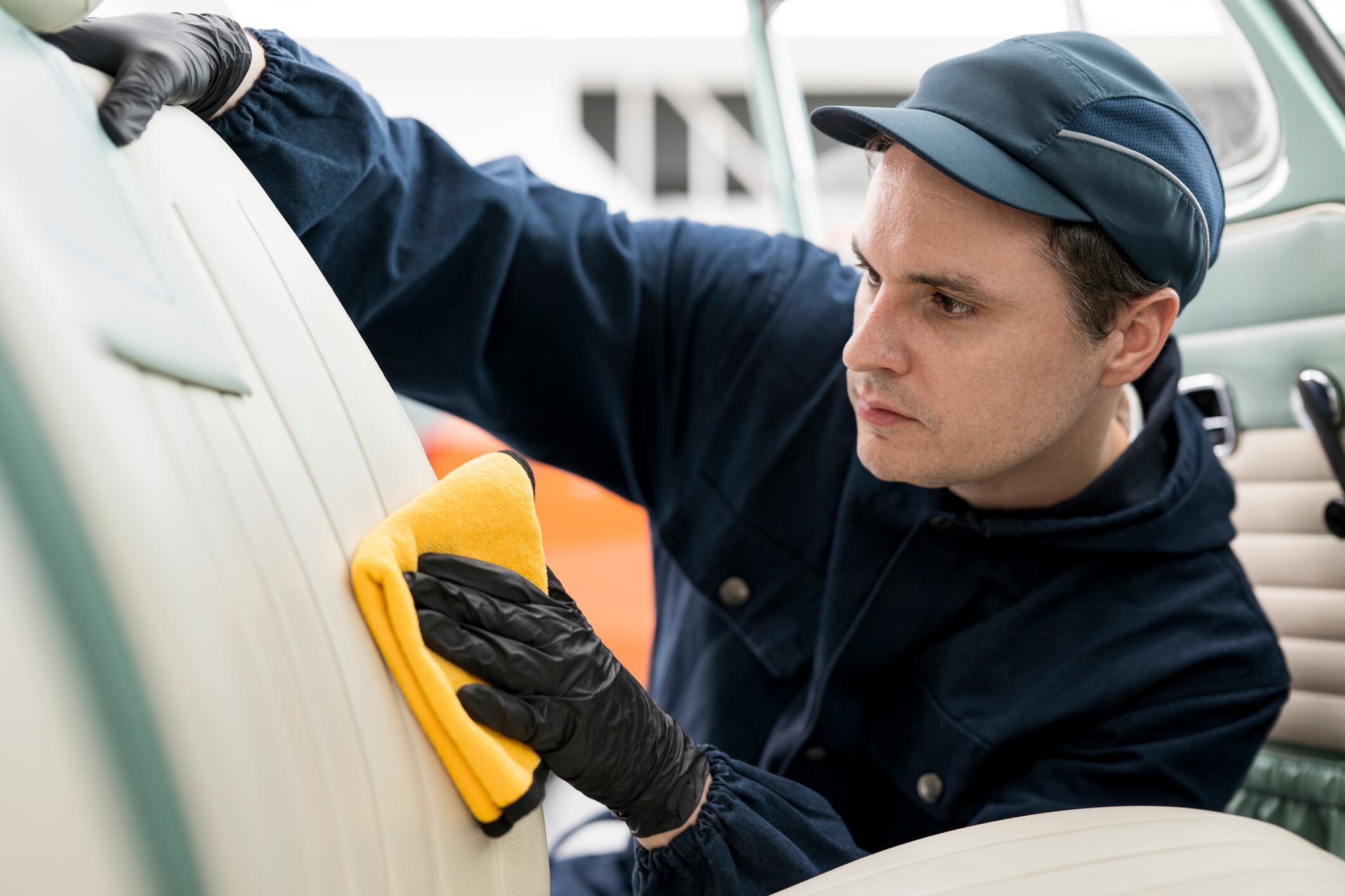 Hombre limpiando tapizado de un carro // Foto de referencia: Getty Images