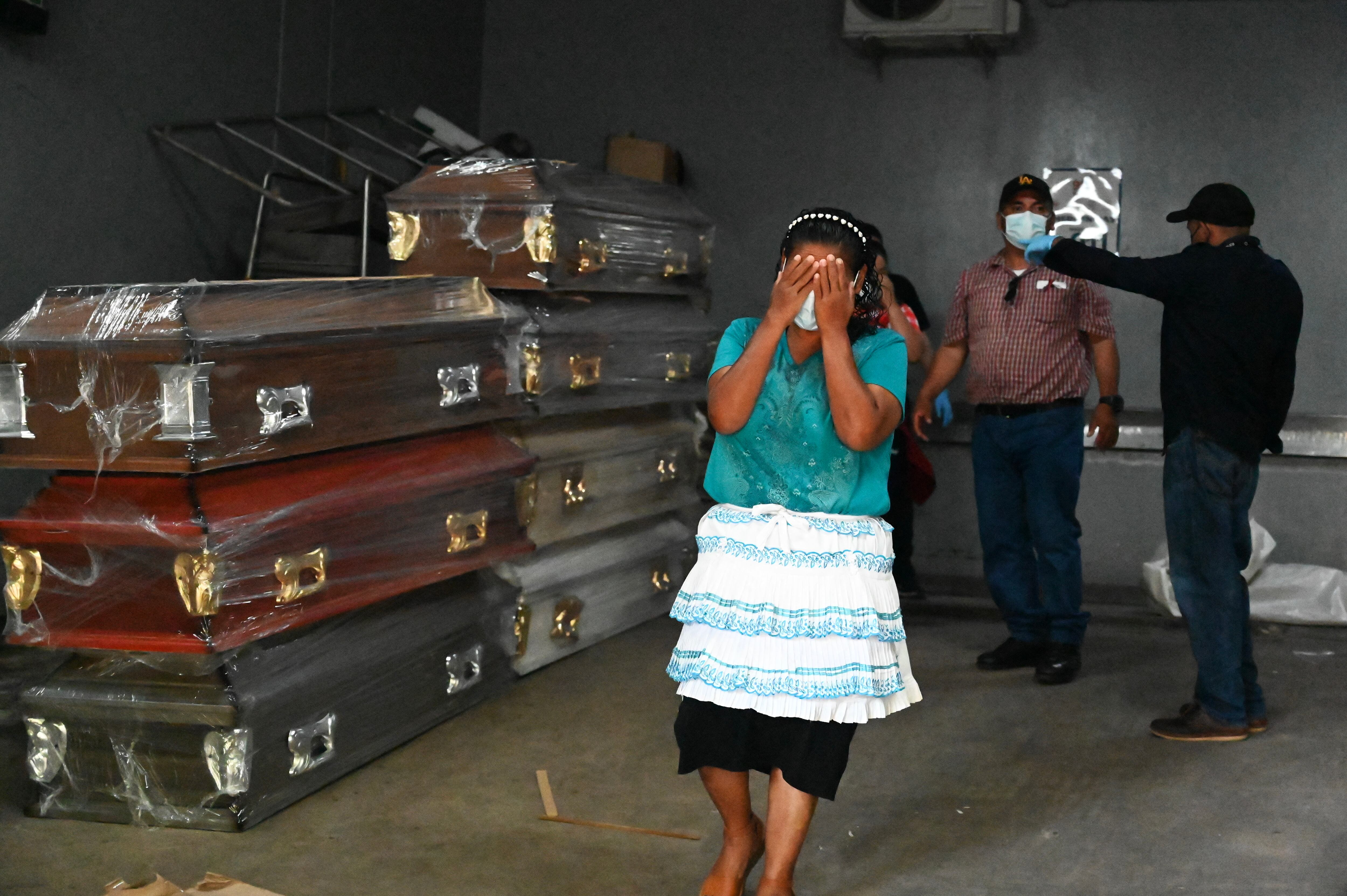 A woman cries after recognising her daughter among the 46 dead women during a fire following a brawl between inmates of the Women's Social Adaptation Center (CEFAS) prison, at the court morgue of Tegucigalpa on June 21, 2023. The death toll from a fire and violent clashes between rival gangs at a women's prison in Honduras has risen to 46, the prosecutor's office said Wednesday, raising the official count from 41. (Photo by Orlando SIERRA / AFP)