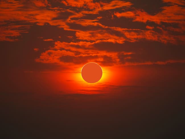 Eclipse solar anular siendo visualizado con el cielo de color naranja. (Foto vía Getty Images)
