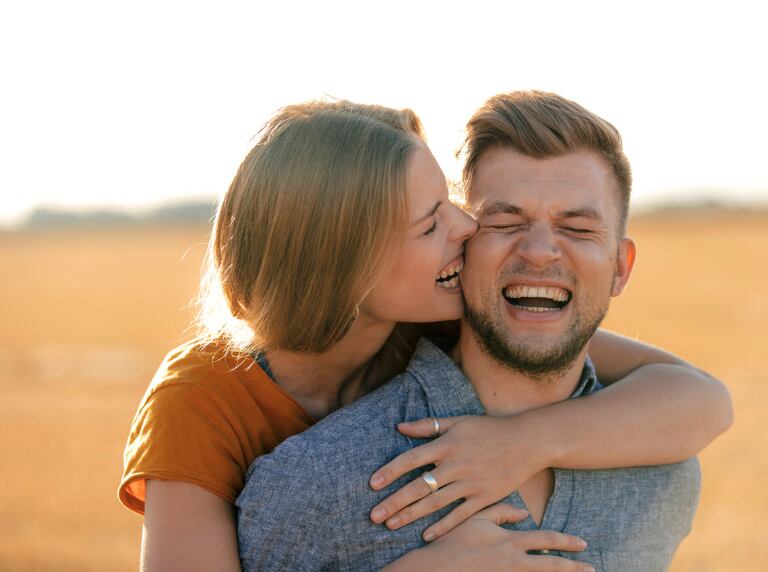 Mujer mordiendo a su pareja en la mejilla (Getty Images)