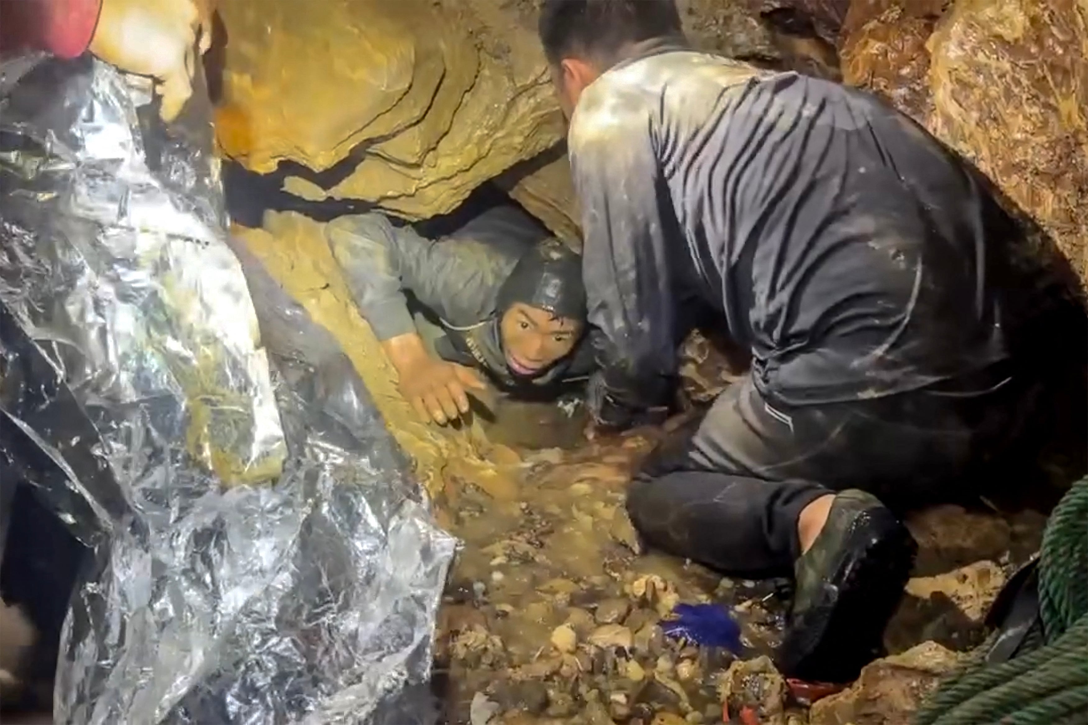 Esta captura de pantalla, tomada de un video facilitado el 29 de mayo de 2026 y proporcionado por Metta Tham Rescue Kalasin, muestra a un equipo de rescate liberando a uno de los siete hombres (izq.) atrapados dentro de una cueva semisumergida en la provincia central de Xaysomboun, al noreste de la capital, Vientiane. Un equipo de rescate liberó el 29 de mayo a uno de los siete hombres atrapados dentro de una cueva semisumergida en Laos durante más de una semana, según informó el grupo que trabajaba en el lugar. (Foto de Handout / Metta Tham Rescue Kalasin / AFP) / RESTRINGIDO A USO EDITORIAL - CRÉDITO OBLIGATORIO "AFP PHOTO/ HO/ Metta Tham Rescue Kalasin - PROHIBIDO SU USO EN CAMPAÑAS DE MARKETING O PUBLICIDAD - DISTRIBUIDO COMO UN SERVICIO A LOS CLIENTES - PROHIBIDO SU ARCHIVO