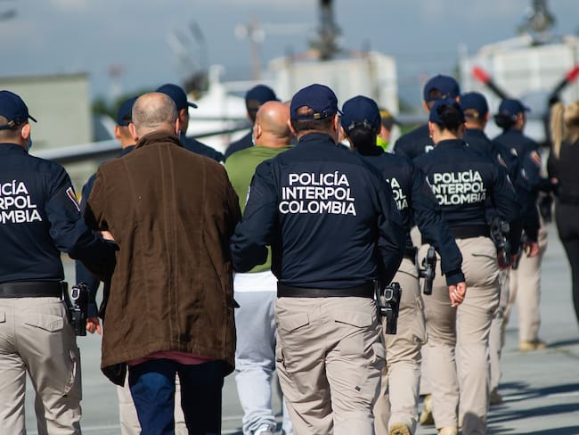 Oficiales de la Interpol escoltando extraditados a Estados Unidos. FOTO: Stringer/Long Visual Press/Universal Images Group via Getty Images)
