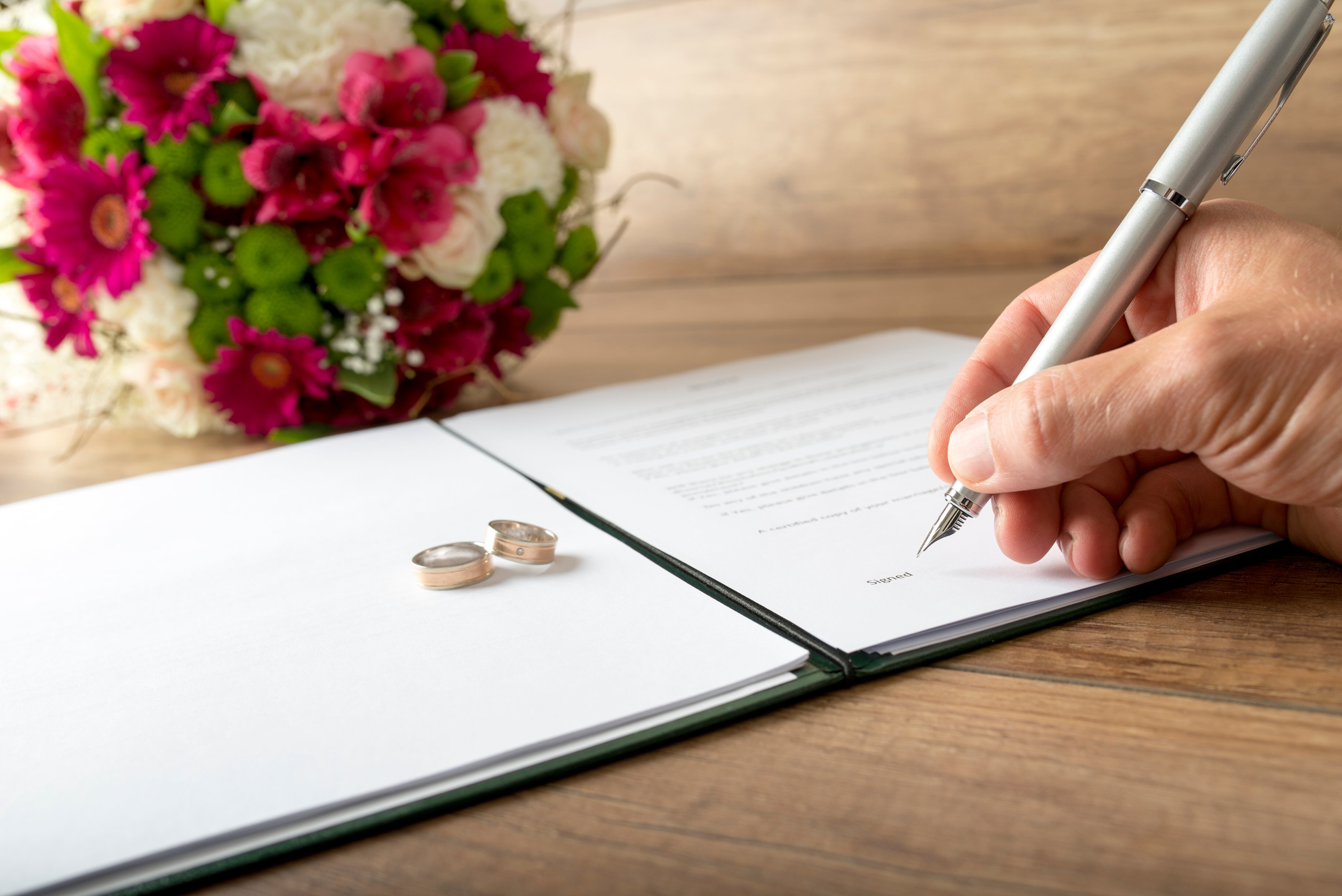 Persona firmando un documento de matrimonio (Foto vía Getty Images)