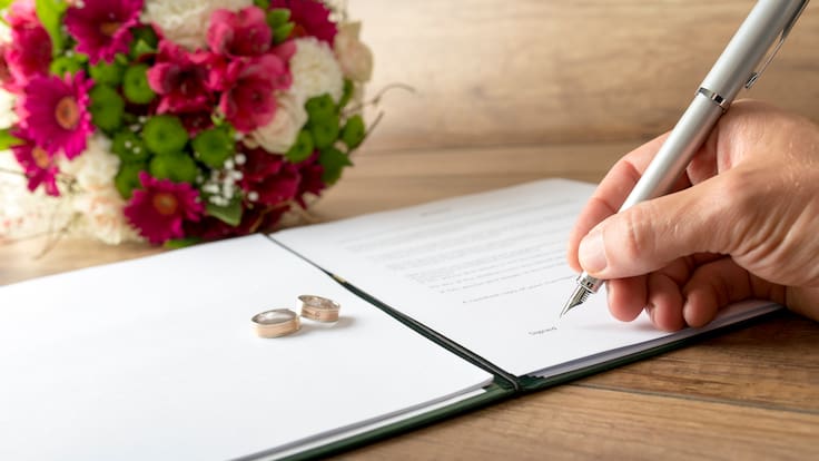 Persona firmando un documento de matrimonio (Foto vía Getty Images)