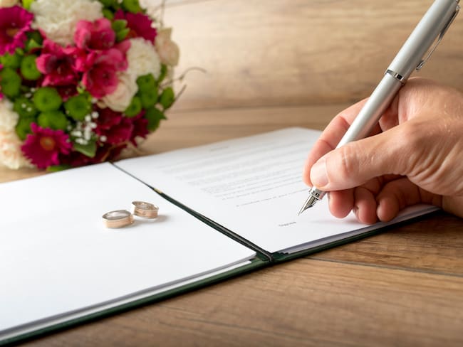 Persona firmando un documento de matrimonio (Foto vía Getty Images)