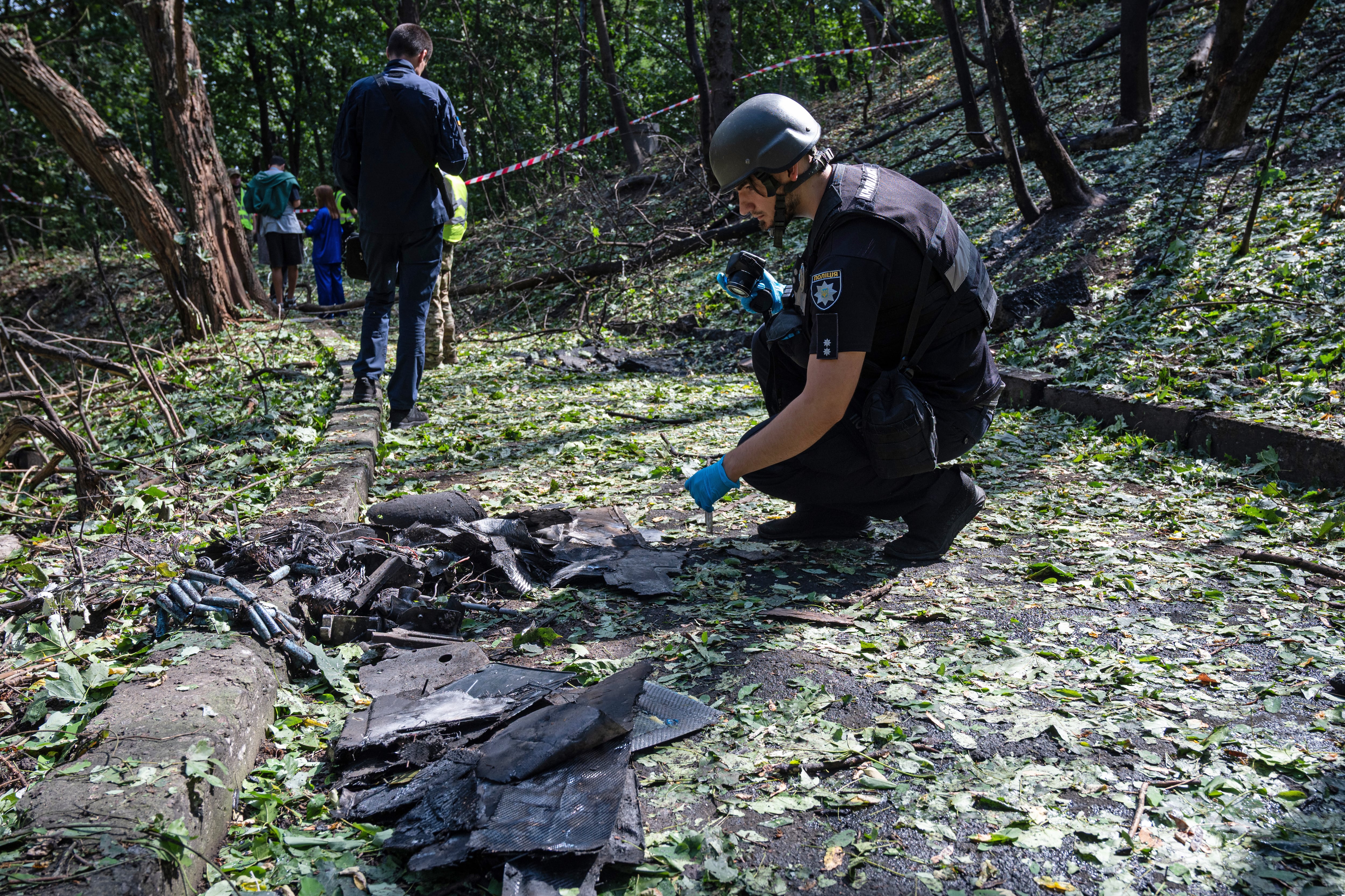 A forensic expert from Ukraine's National Police takes pictures of fragments of a Russian drone found on Parkova Doroha. Imagen tomada de Getty Imagenes