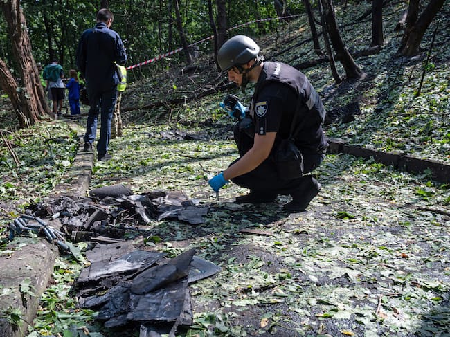 A forensic expert from Ukraine's National Police takes pictures of fragments of a Russian drone found on Parkova Doroha. Imagen tomada de Getty Imagenes