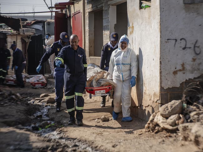 Oficiales mueven los cuerpos de los fallecidos en Johannesburgo, Sudáfrica (Photo by Ihsaan Haffejee/Anadolu via Getty Images)