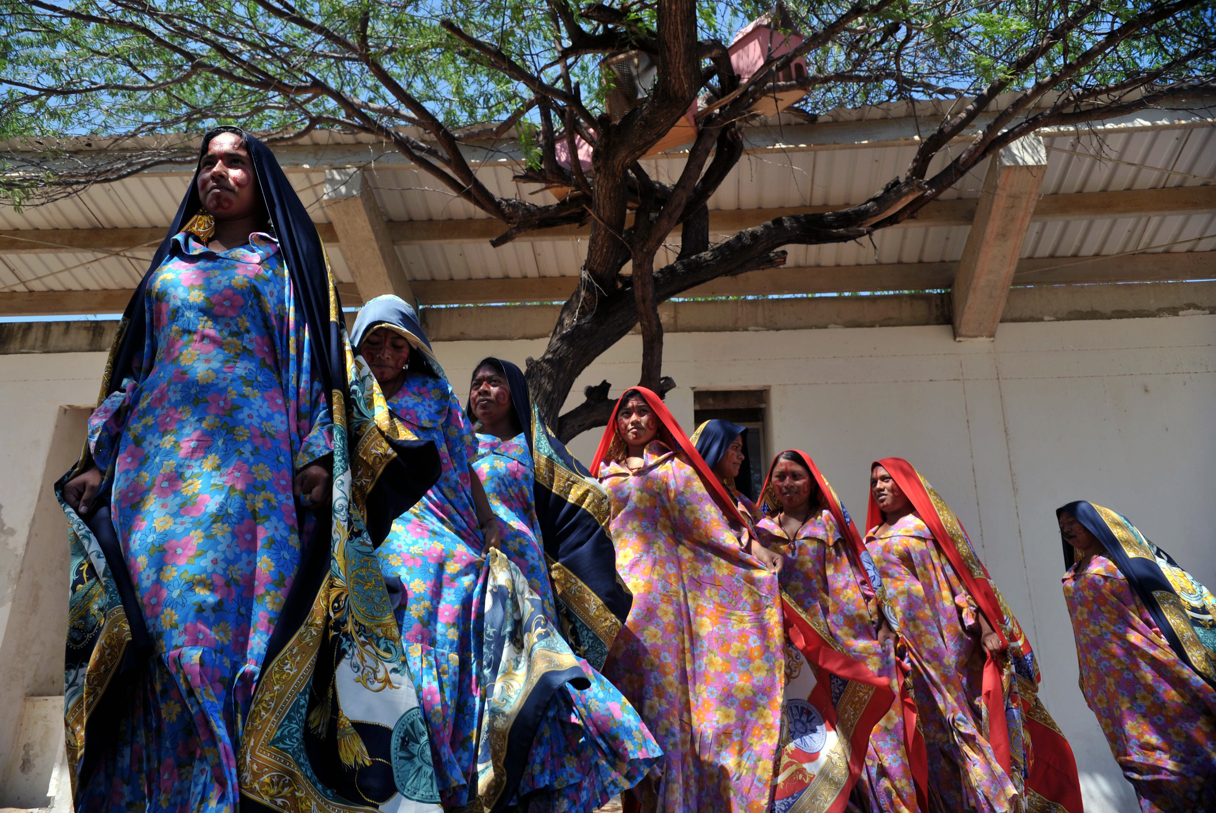 Colombian Wayuu indigenous women dance during a meeting between the army and villagers of the town of Uribia, in La Guajira Department, close to the border with Venezuela on January 30, 2010. Colombian President Alvaro Uribe will preside a security council on Tuesday in La Guajira. AFP PHOTO/Guillermo Legaria (Photo credit should read GUILLERMO LEGARIA/AFP via Getty Images)
