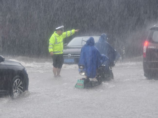 Autoridades en medio de las fuertes lluvias en China producto del paso de un tifón. 
(Foto:   CFOTO/Future Publishing via Getty Images)