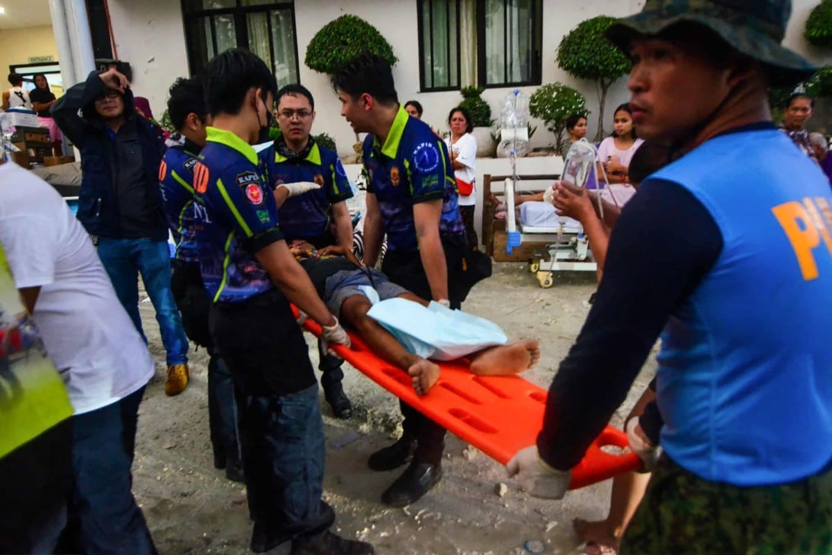 The police and rescuers carry an injured person as they are brought to the hospital in Bogo City, Cebu province, central Philippines, on October 1, 2025, after a powerful 6.9-magnitude earthquake jolted the central Philippines, collapsing buildings and killing at least 19 people. The shallow quake struck at 9:50 pm (1359 GMT) on September 30 off the island's northern end near Bogo, a city of 90,000 people, according to the US Geological Survey (USGS). (Photo by Alan Tangcawan / AFP)