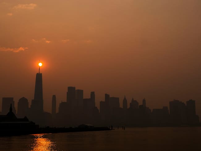 El sol sale detrás del One World Trade Center, mientras que el humo de los incendios forestales de Canadá cubre el distrito de Manhattan el 8 de junio de 2023 en Nueva Jersey. (Foto de Eduardo Muñoz Álvarez/Getty Images)