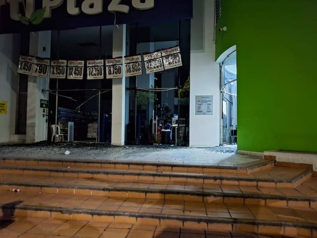 Granada de fragmentación afectó la fachada de supermercado surtiplaza.