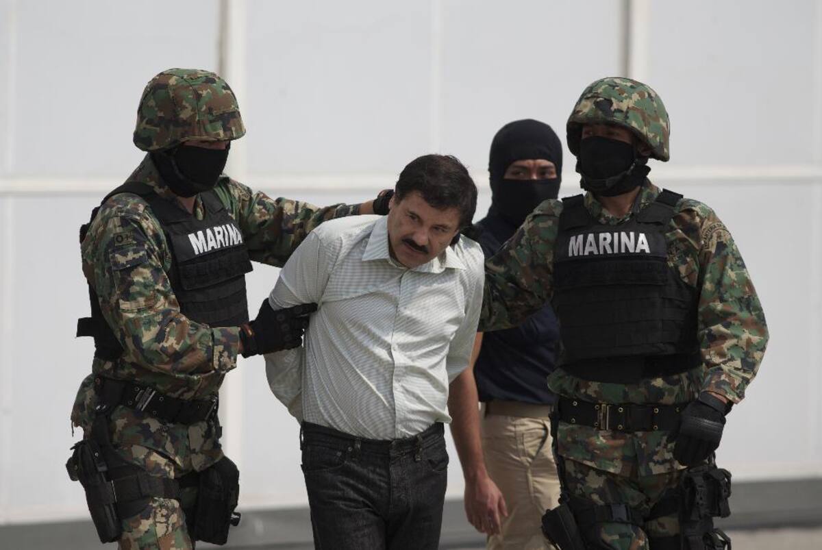 Joaquín 'El Chapo' Guzmán es escoltado a un helicóptero con las manos esposadas, tras su captura en febrero de 2014.