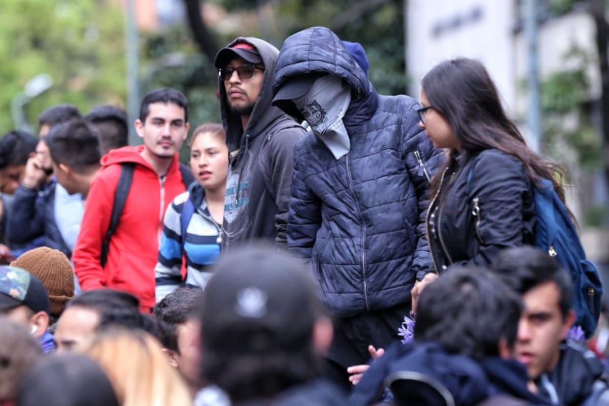 Un encapuchado en medio de los estudiantes.
