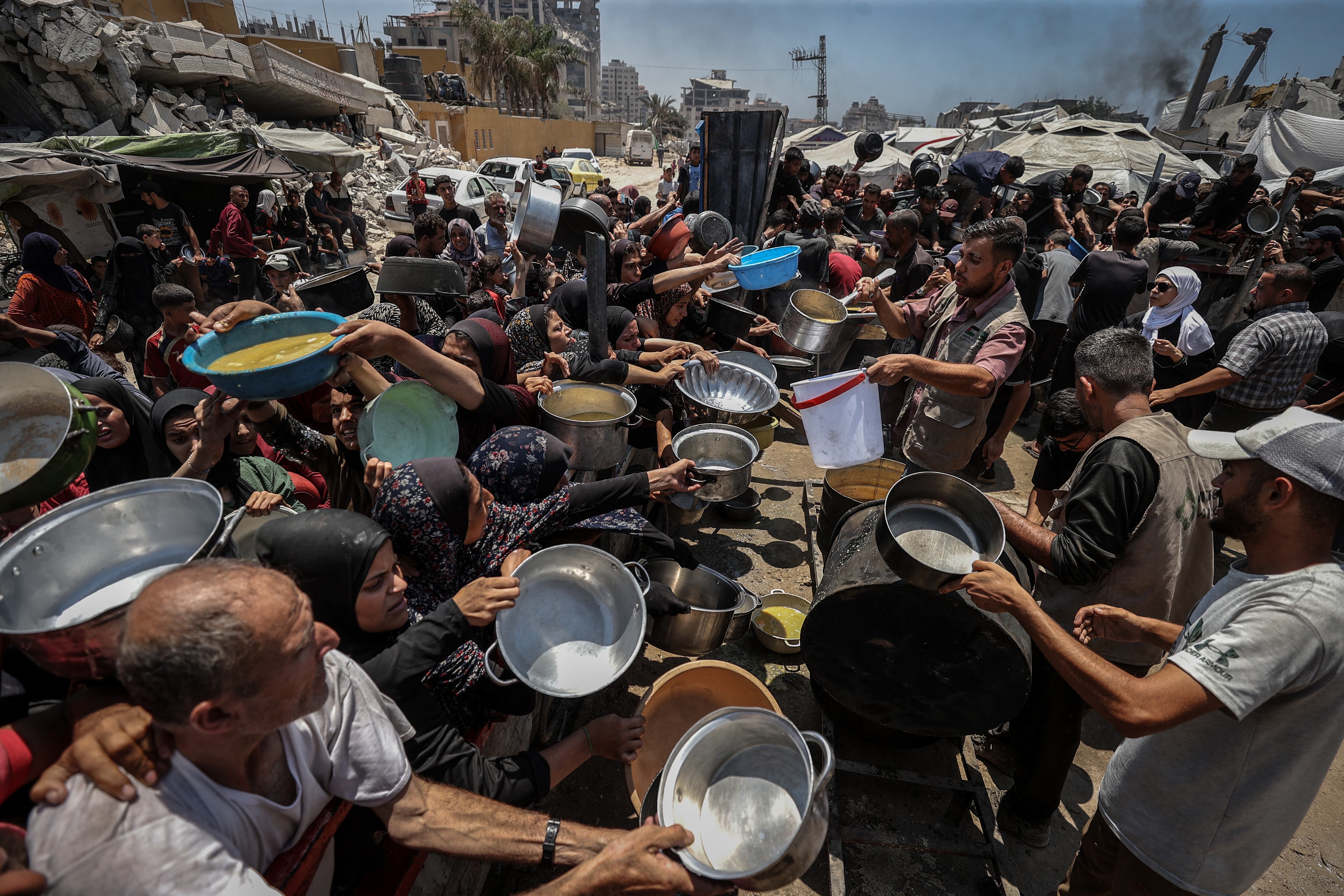 GAZA CITY, GAZA - JULY 22: Crowds form as Palestinians, including children, line up in Gaza City, Gaza to receive food distributed by a charity amid ongoing Israeli blockade and attacks on Gaza on July 22, 2025. (Photo by Ali Jadallah/Anadolu via Getty Images)
