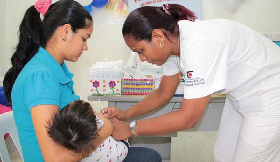 Enfermera vacunando a un bebé