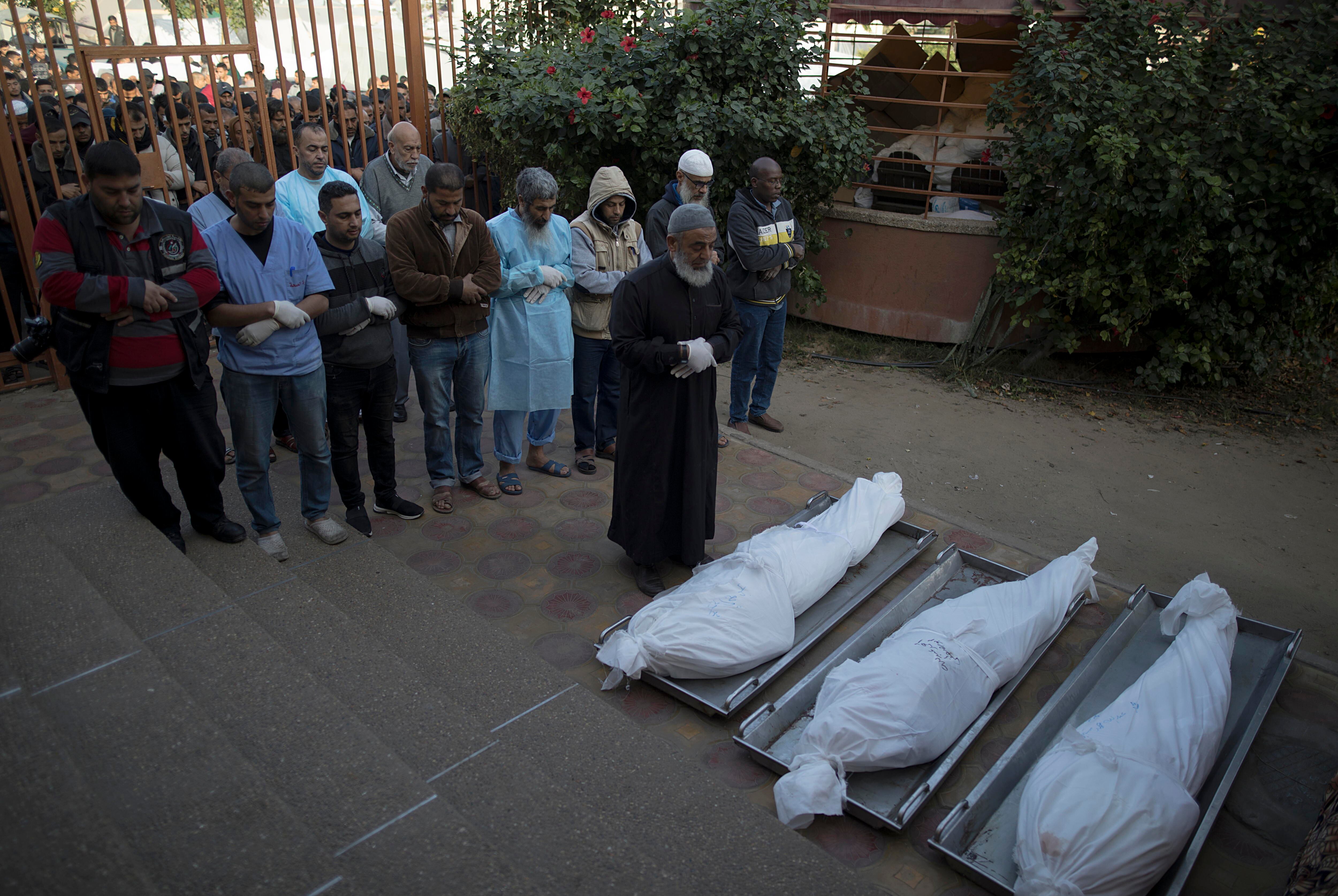 Khan Yunis (-), 12/12/2023.- Relatives of Palestinians who died during Israeli air strikes in the southern Gaza Strip, accompanied by medical staff, pray in front of their wrapped bodies, outside Nasser Hospital in Khan Yunis, southern Gaza Strip, 12 December 2023. Israeli forces resumed military strikes on Gaza after a week-long truce expired on 01 December. More than 18,000 Palestinians and at least 1,200 Israelis have been killed, according to the Palestinian Health Ministry and the Israel Defense Forces (IDF), since Hamas militants launched an attack against Israel from the Gaza Strip on 07 October, and the Israeli operations in Gaza and the West Bank which followed it. EFE/EPA/HAITHAM IMAD
