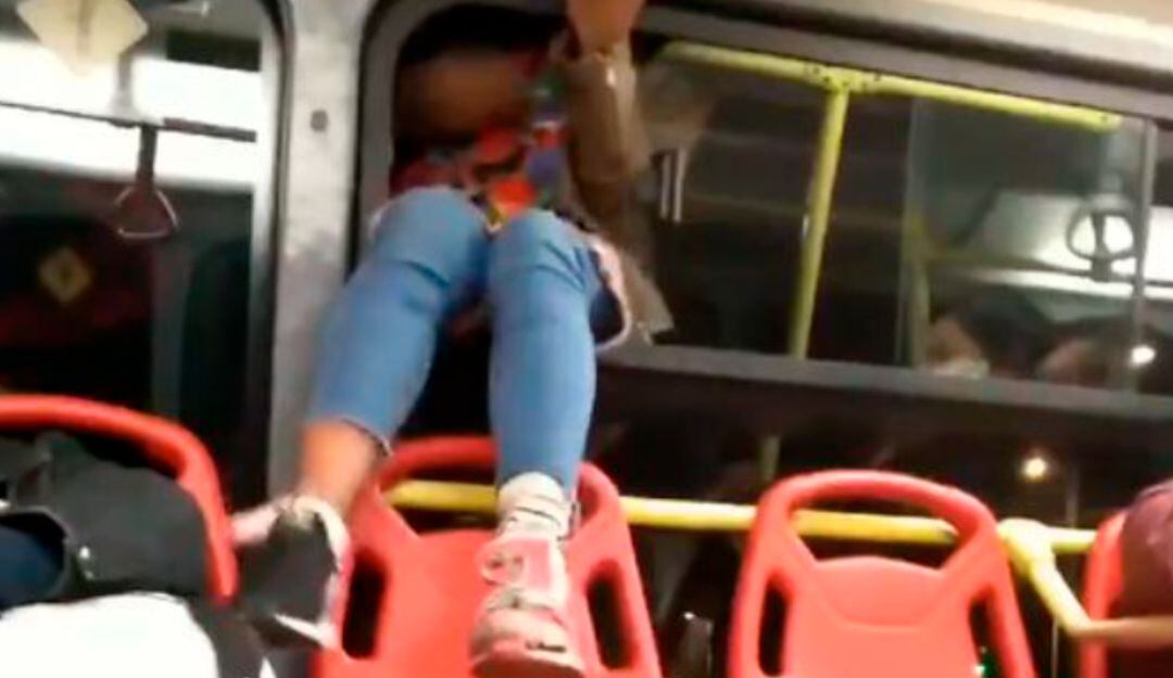 Mujer se baja de un Transmilenio por la ventana