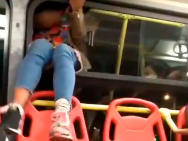Mujer se baja de un Transmilenio por la ventana