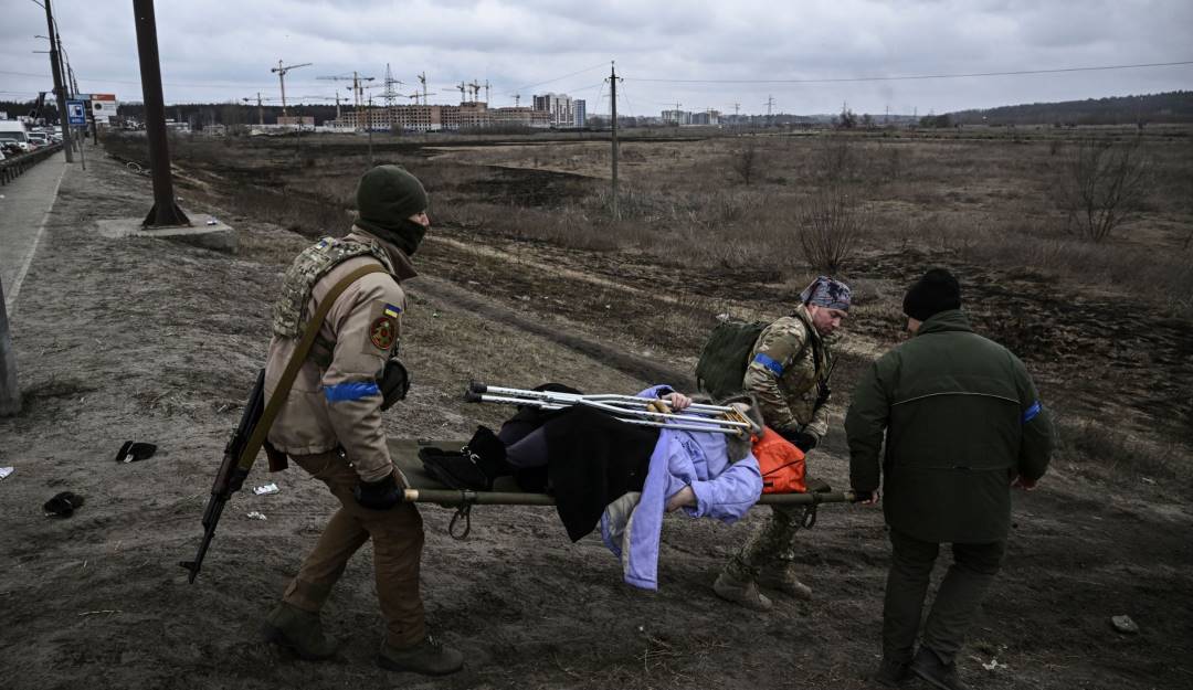 Soldados ayudan a una mujer herida en Irpin. Foto: Getty