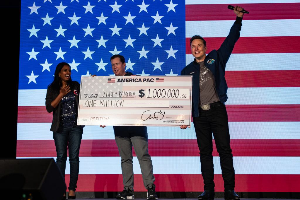 Elon Musk awards Judey Kamora with $1,000,000 during an America PAC town hall on October 26, 2024 in Lancaster, Pennsylvania. Musk has donated more than $75 million to America PAC, which he co-founded with fellow Silicon Valley venture capitalists and tech businessmen to support Republican presidential nominee, former U.S. President Donald Trump. (Photo by Samuel Corum/Getty Images)