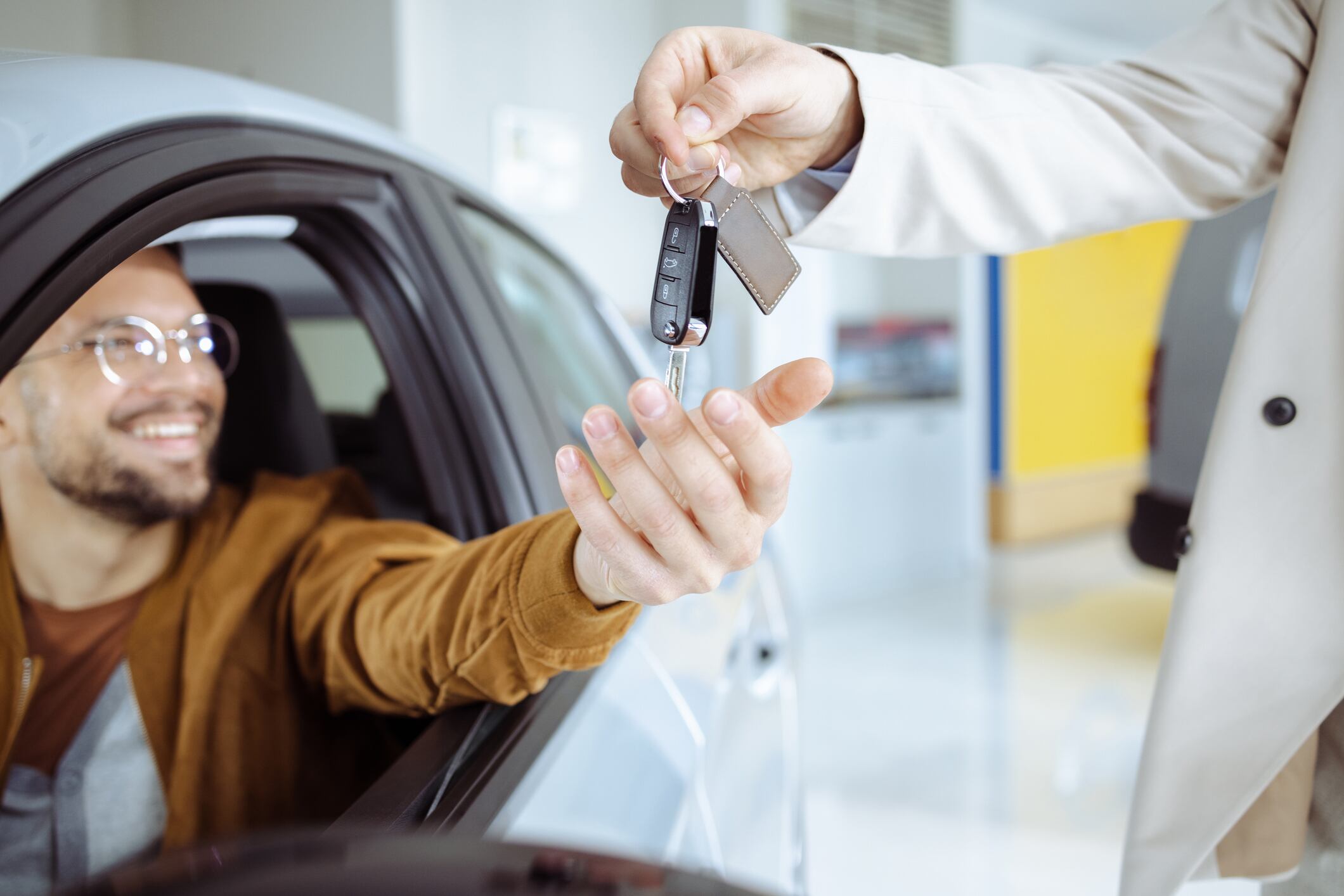 Hombre recibiendo las llaves de un carro nuevo (Foto vía Getty Images)