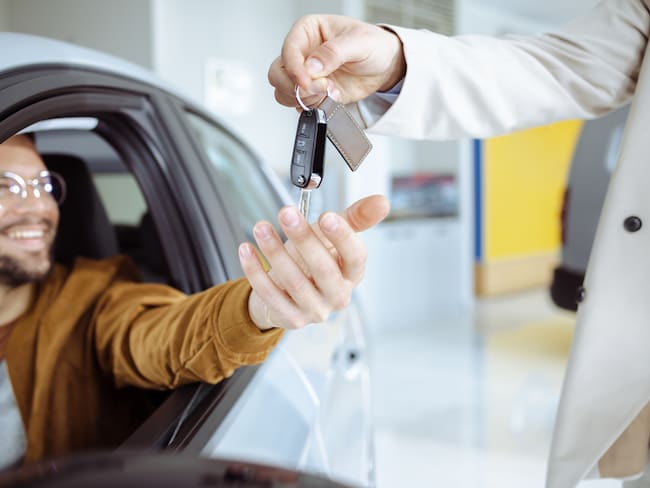 Hombre recibiendo las llaves de un carro nuevo (Foto vía Getty Images)
