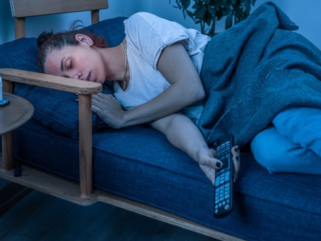 Mujer dormida con el televisor encendido // imagen de referencia: GettyImages