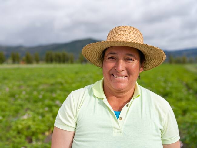 Portrait of a Latin American woman working in agriculture at a rural farm and looking at the camera smiling