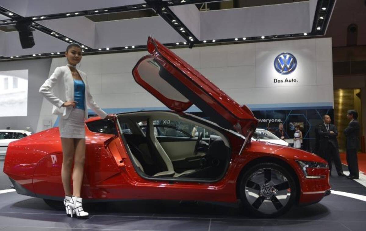 Una modelo posa junto al Volkswagen XL1 expuesto en el 43º Salón del Automóvil deTokio (Japón)