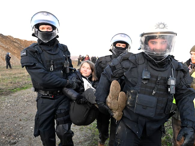 Tres policías cargan a la activista climática, Greta Thunberg, que protestaba en la mina Garzweiler II. 
(Foto: Roberto Pfeil/picture alliance via Getty Images)