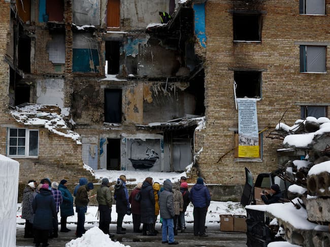 HORENKA, UKRAINE - NOVEMBER 22: Members of public queue for food beside a picture  by graffiti artist Banksy on a the wall of a destroyed building  on November 22, 2022 in Horenka, Ukraine. The elusive British artist posted a video to Instagram last week that suggested he&#039;s behind the spray-painted artworks that have appeared across the Ukrainian capital this month. (Photo by Jeff J Mitchell/Getty Images)