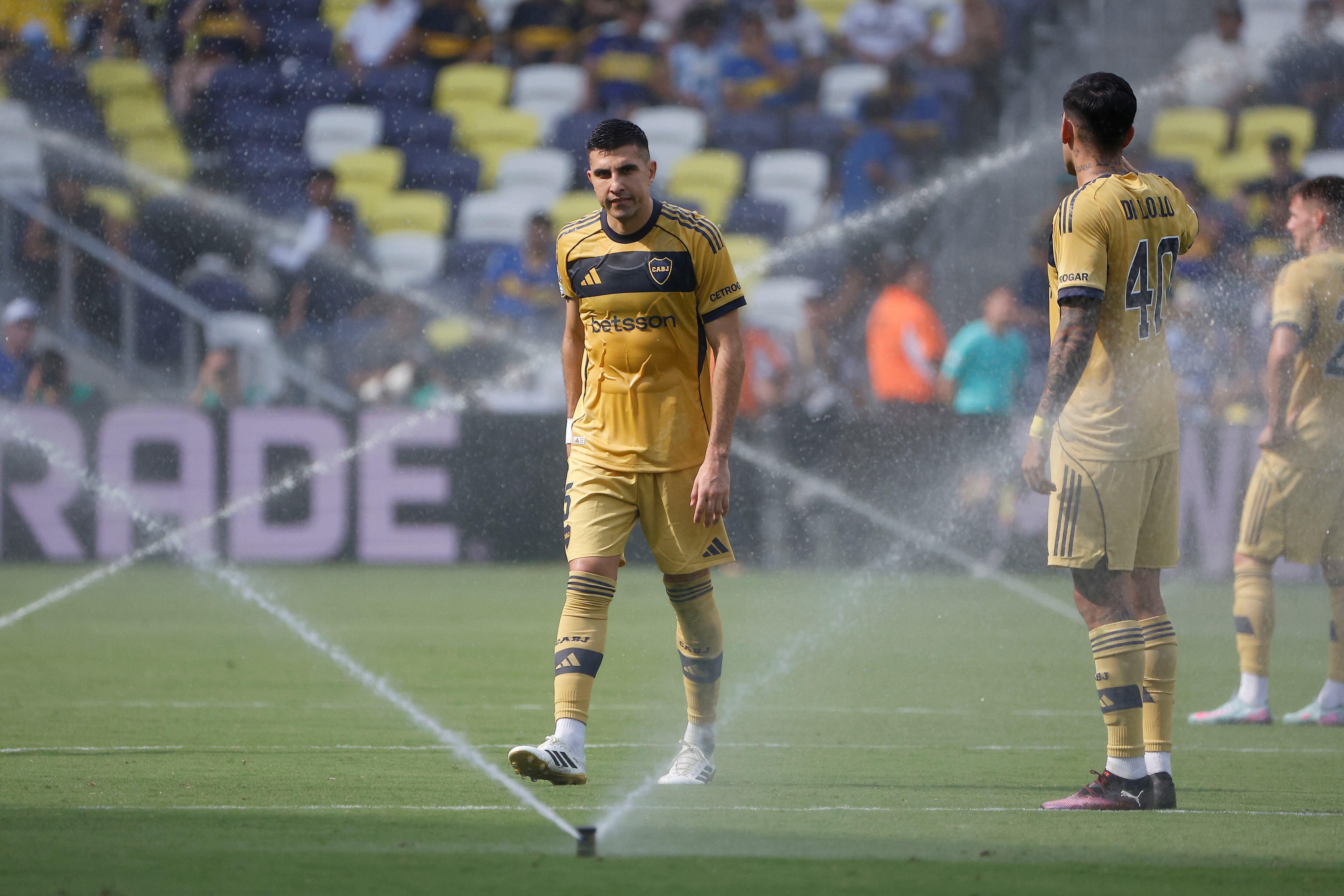 EVE6411. NASHVILLE (ESTADOS UNIDOS), 24/06/2025.- Rodrigo Battaglia (i) y Lautaro Di Lollo de Boca caminan entre los dispensadores de riego de agua este martes, en un partido del Mundial de Clubes entre Auckland City y Boca Juniors en el estadio Geodis Park en Nashville (EE.UU.). EFE/ Juan Ignacio Roncoroni