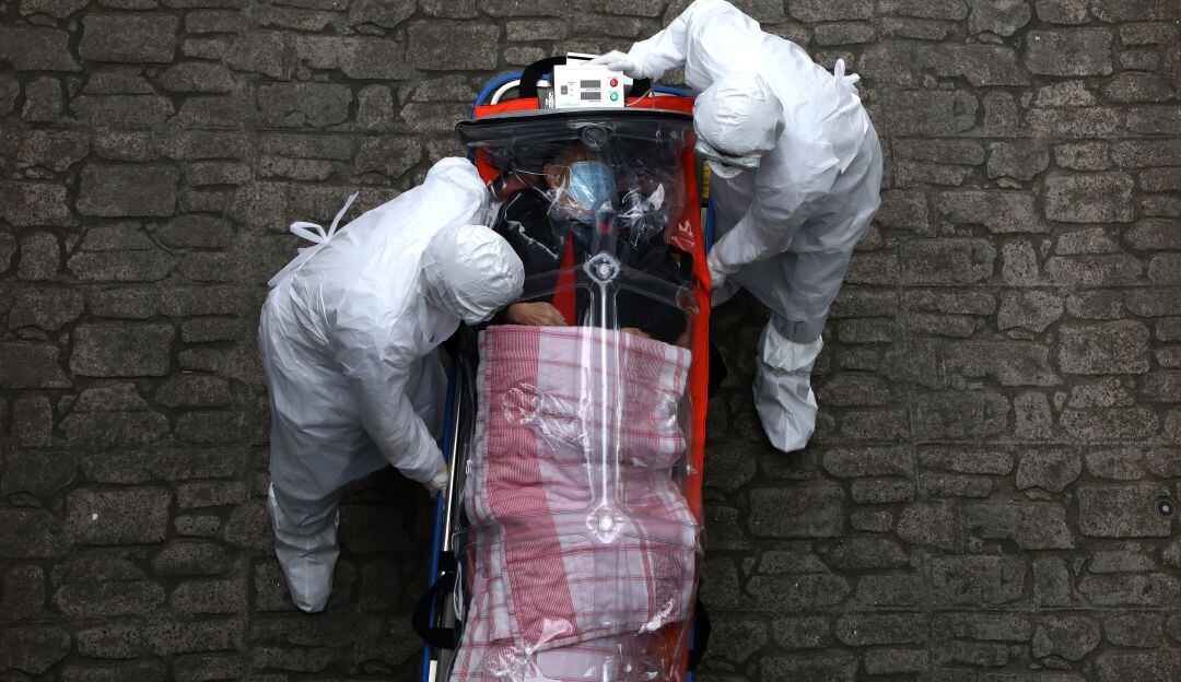 Trabajadores médicos de Corea del Sur trasladan un paciente crítico contagiado con coronavirus.